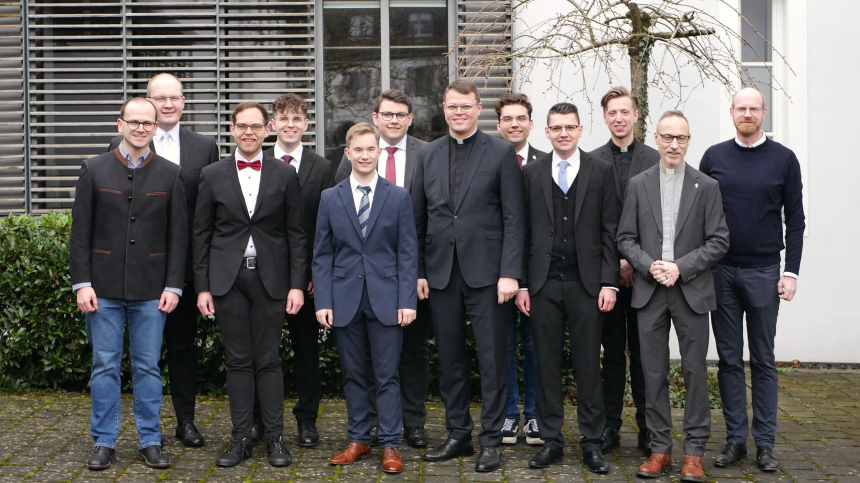 Zu sehen ist ein Gruppenfoto: In zwei Reihen stehen die Seminaristen, gemeinsam mit Regens Tim Sturm und Spiritual Jan Lehmann. Sie tragen fast alle einen Anzug und lächeln freundlich.