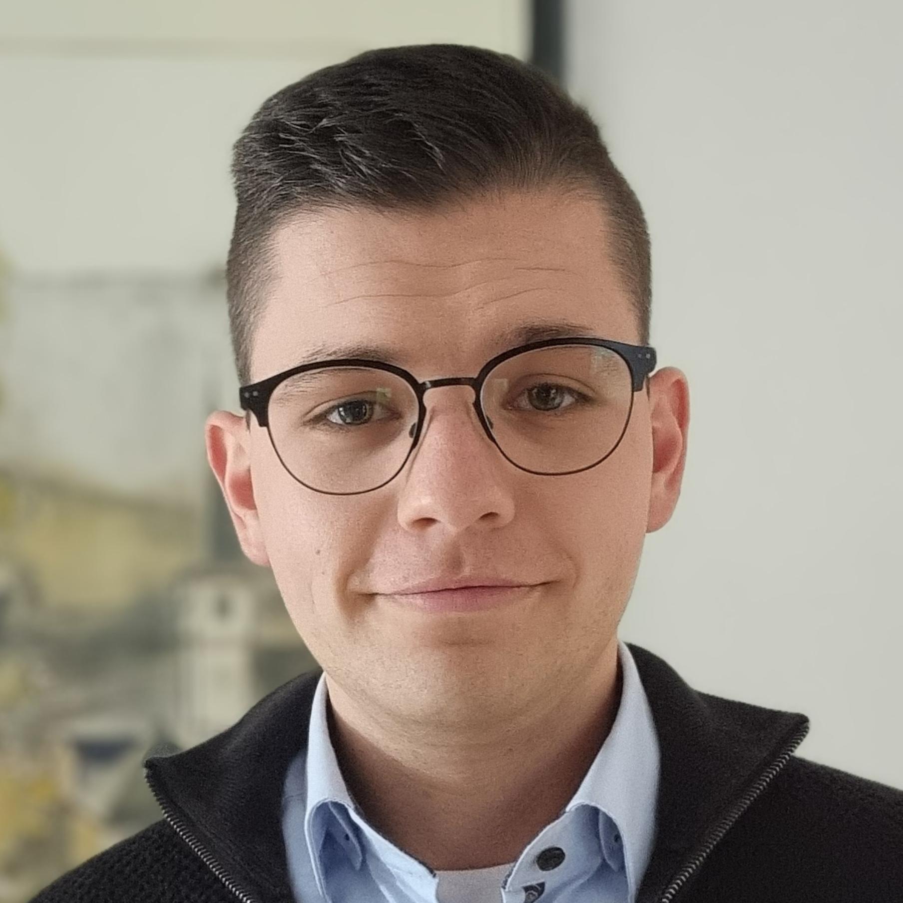 Portraitfoto von Manuel Hauth, der vor einem Gemälde steht.