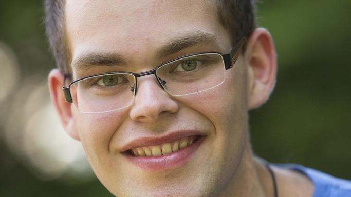 Portraitfoto von Mathias Kremer, vor einem grünen, unscharfen Hintergrund.