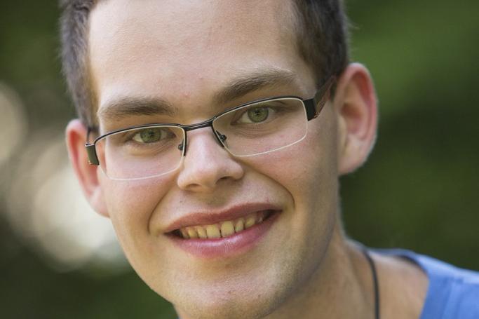 Portraitfoto von Mathias Kremer, vor einem grünen, unscharfen Hintergrund.