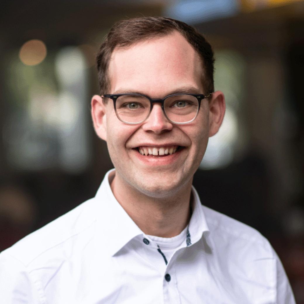Portraitfoto von Mathias Kremer vor einem unscharfen Hintergrund.